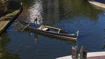 A narrow waterway with a small boat being towed by a person.