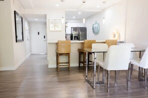A modern kitchen with a refrigerator, stove, and dining area with chairs and a table. - La Casa Maya: Modern 2bd/2br condo near Old Town. Can't beat this location!  (Scottsdale)