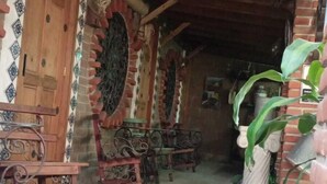 A rustic wooden interior with a tiled floor, wooden furniture, and a brick wall. - HOSTAL EL REFUGIO (Puebla)