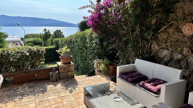 An outdoor patio with wicker furniture, a glass-top table, and potted plants. - Tuscany, Ansedonia - Villa for 7 people with swimming pool (Ansedonia)