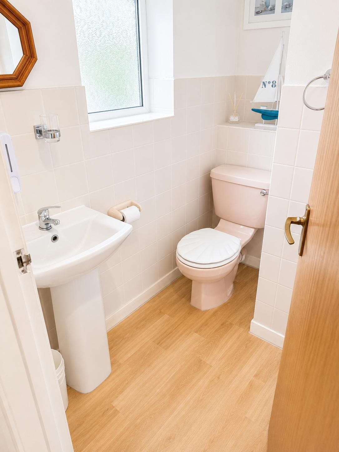 A bathroom with a white sink, a toilet, and a window.