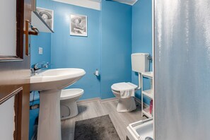 A bathroom with a white sink, two toilets, and a blue wall. - Pavone - Sweet Dreams in Florence (Firenze)