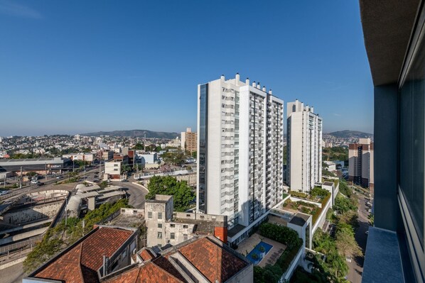 Un edificio de gran altura con múltiples balcones, rodeado de otros edificios y vegetación.