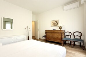 A bedroom with a bed, dresser, chairs, and a painting on the wall. - SE061 - Senigallia, large three-room apartment with terrace (Senigallia)