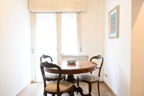 A dining area with a round table, four chairs, and a window with blinds. - SE061 - Senigallia, large three-room apartment with terrace (Senigallia)
