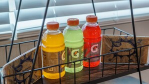 A metal rack with three Gatorade bottles in yellow, green, and red.