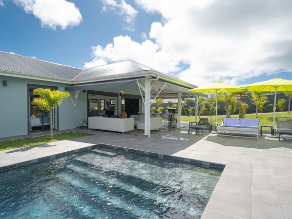 A modern house with a swimming pool, outdoor seating, and a covered patio area. - Villa Maxence remarkable elegance, experience a dream getaway (Saint-François)
