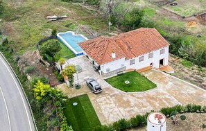 A white house with a red-tiled roof, a swimming pool, and a car parked in the driveway. - Cozy home in La Puebla de los Infan (La Puebla de los Infan)
