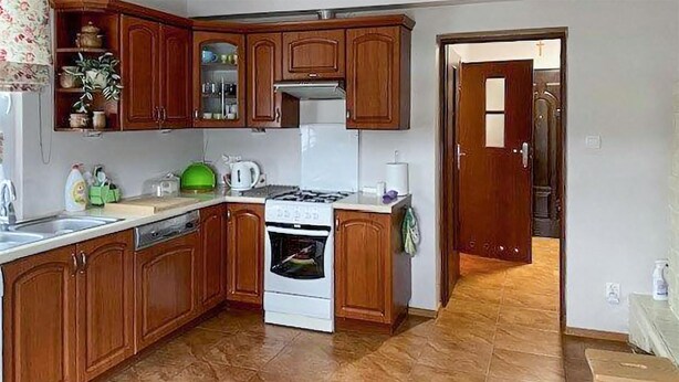 Una cocina con armarios de madera, una estufa y un lavabo.