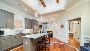 A spacious kitchen with a central island, wooden flooring, and modern cabinetry.