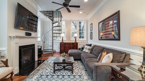 A living room with a fireplace, a sofa, a coffee table, and a staircase.