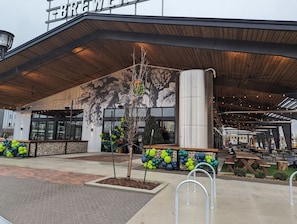 A modern building with a large sign reading 'BREWERY' and a mural of a tree on the facade.