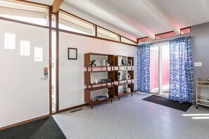 A traditional Japanese-style room with sliding doors, a wooden bookshelf, and a view through a glass door.