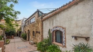 A narrow alley with traditional stone buildings, a tiled entrance, and lush greenery. - Amazing home in Trappeto with house sea view (Trappeto)