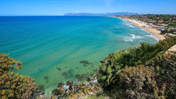 A coastal landscape with clear turquoise waters, a sandy beach, and a view of a town in the distance. - Amazing home in Trappeto with house sea view (Trappeto)