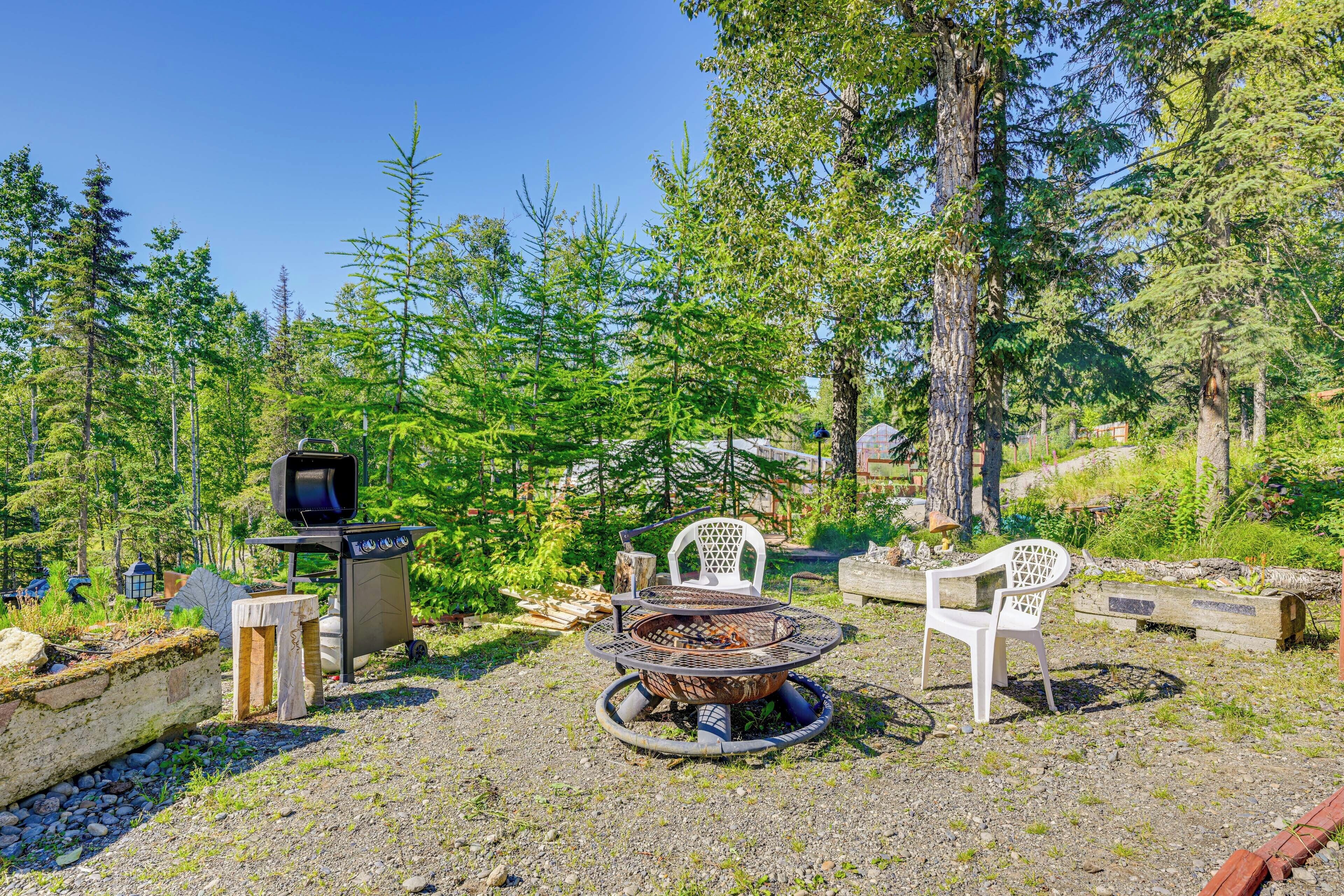 Un espace extérieur aménagé avec un barbecue, des chaises et un téléviseur.