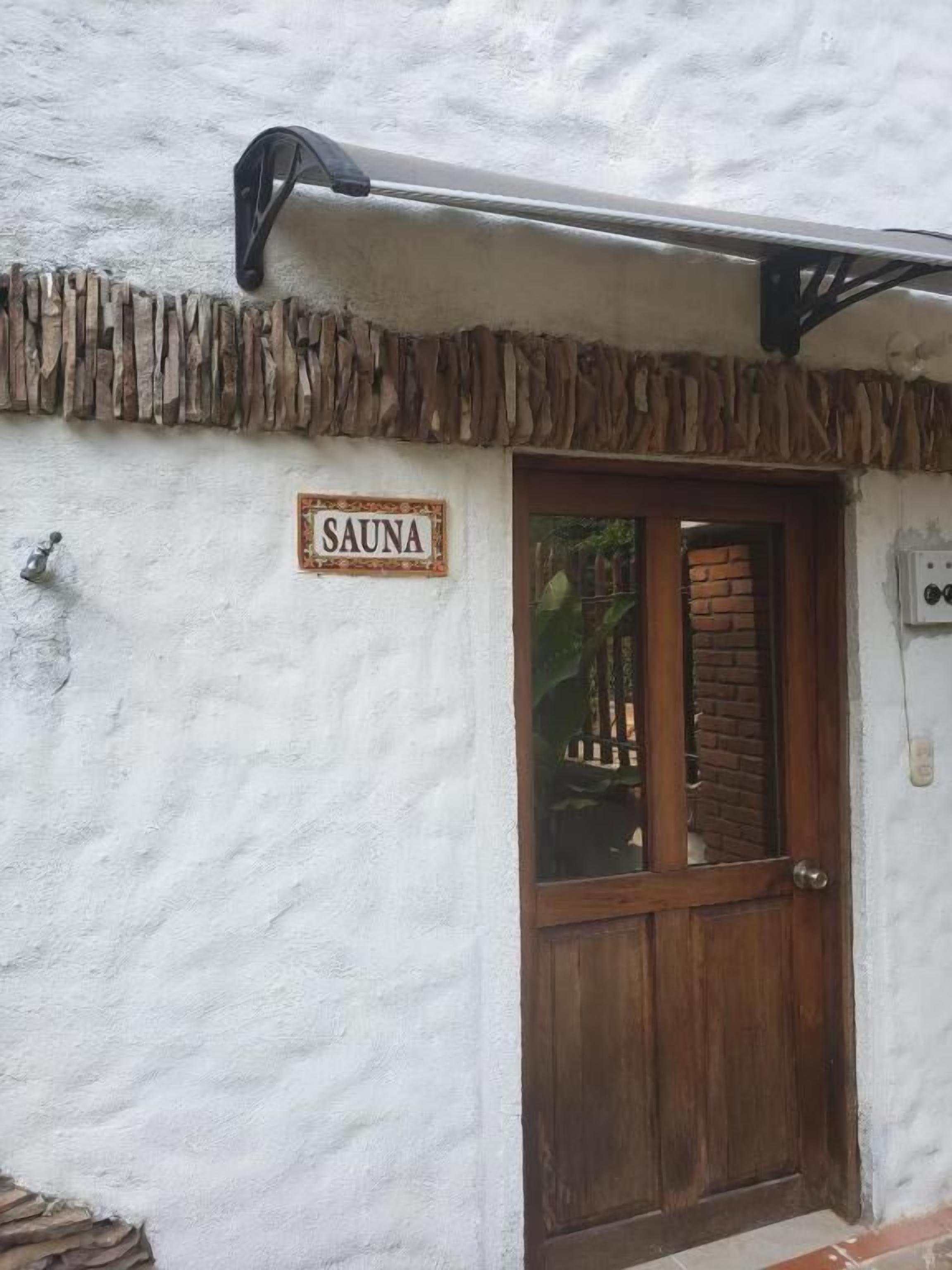 Edificio con un letrero que dice "SAUNA" sobre una puerta de madera.