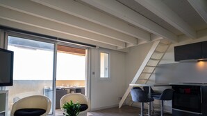 A modern kitchen with a built-in oven, a dining area with a table and chairs, and a large window providing a view of the outdoors.