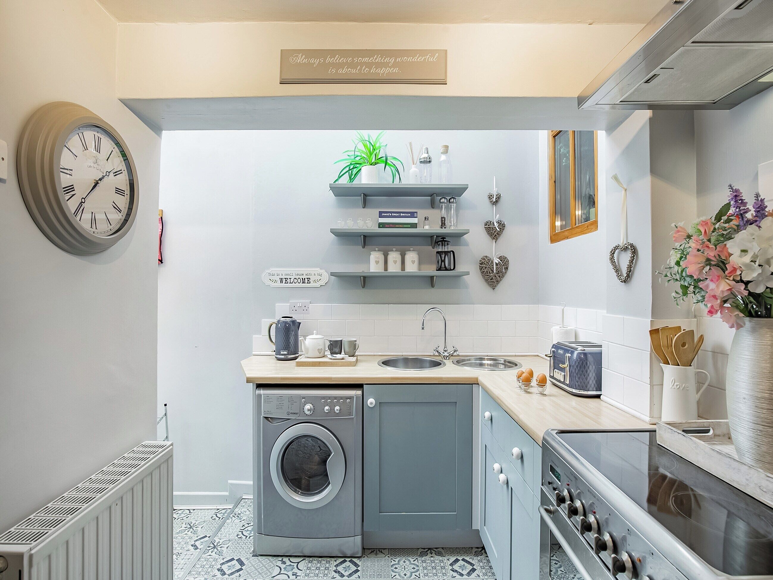 A compact kitchen with a built-in washer and dryer, a sink, and a stove.