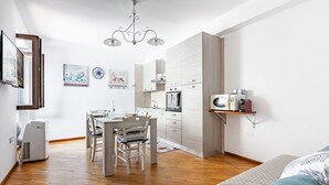 Une cuisine moderne avec un coin repas, un four à micro-ondes et un petit réfrigérateur.