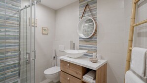 A bathroom with a glass shower enclosure, a toilet, a vanity with a white sink, and a mirror. - GuestHost - Spacious and elegant, finely renovated apartment capable of accommodating up to 6 people, located on the ground floor of a typical ligurian building in the center of Sanremo, a few steps from the famous Casino. Nearby is Via Matteotti, with i (Sanremo)