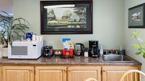A kitchen with a microwave, toaster, coffee maker, and various kitchen items on the counter. - Scenic Motel Moncton  (Berry Mills)