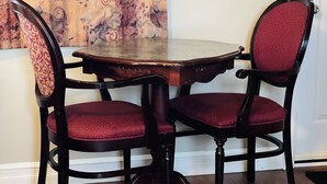 A dining table with two chairs, a patterned curtain, and a white wall. - Scenic Motel Moncton  (Berry Mills)