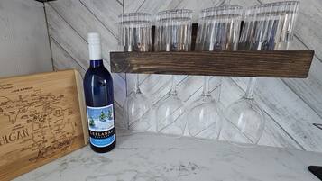 A bottle of Leelanau Cellars Winter White wine, a wooden map, and a wooden wine rack with six glasses.