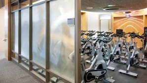 A gym with stationary bikes and a modern interior design. - Walkable, Pet friendly FIDI 1BR w/ Sauna & Rooftop Deck (New York)