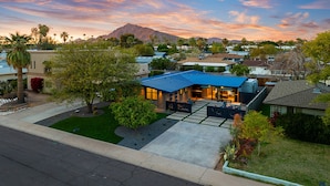A modern house with a blue roof, a well-maintained lawn, and a mountain in the background. - Modern Scottsdale Villa Walk to Old Town , 4BR Pool & Spa (Scottsdale)