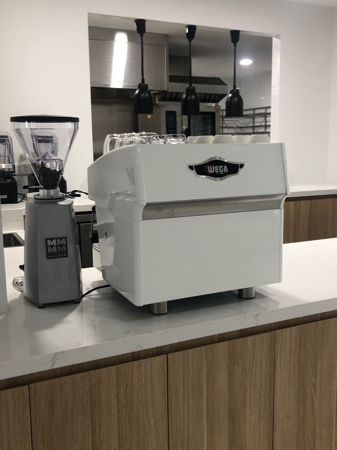 A commercial coffee machine with a branded logo, a grinder, and a coffee dispenser.