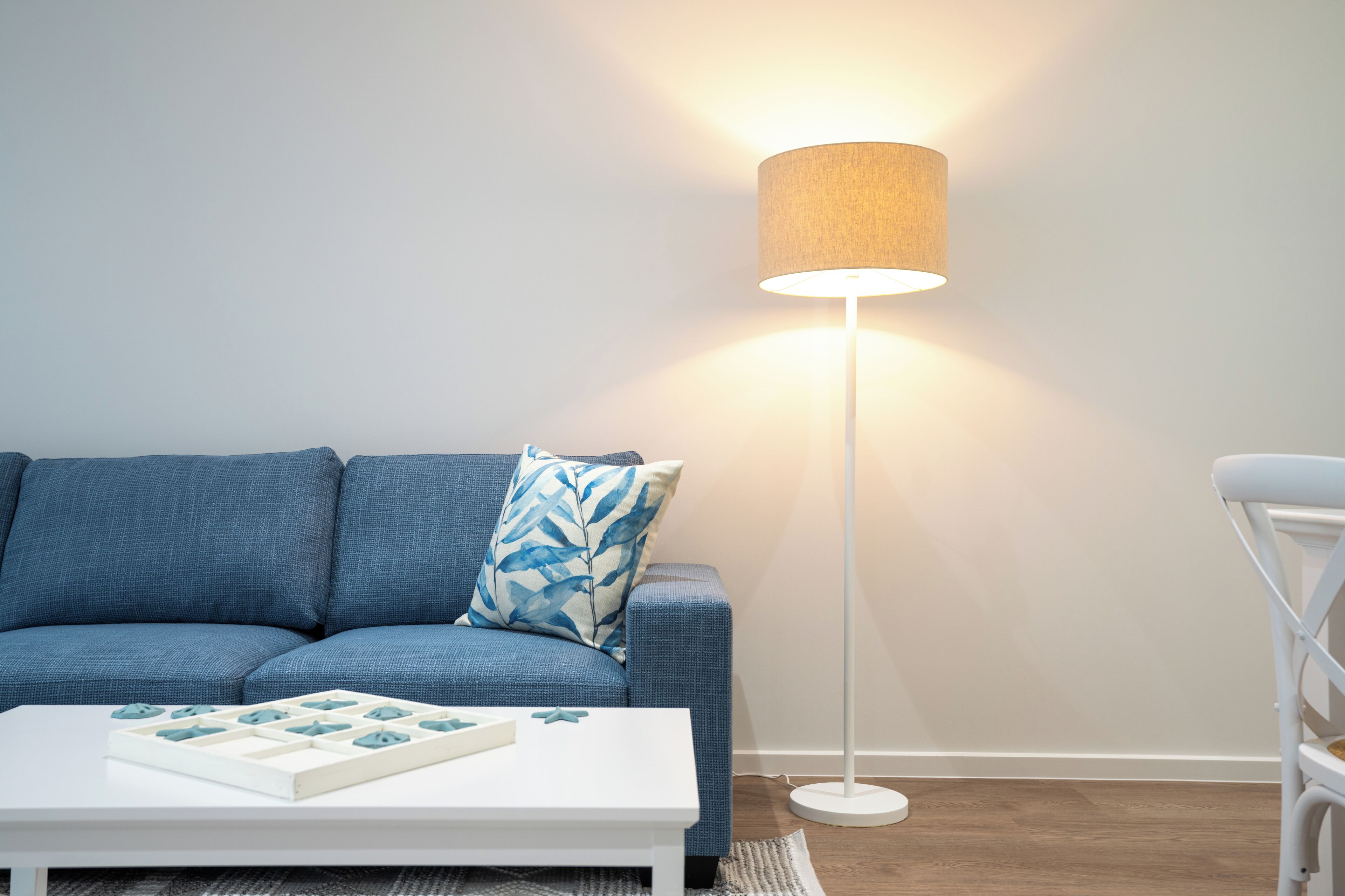 Ein modernes Wohnzimmer mit einer Couch, einem Couchtisch und einer Stehlampe.