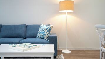 Ein modernes Wohnzimmer mit einer Couch, einem Couchtisch und einer Stehlampe.