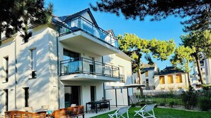 A modern two-story building with a balcony, outdoor seating, and a well-maintained lawn. - Le Sophia à La Baule (La Baule-Escoublac)