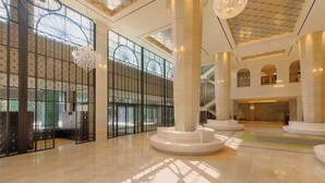 A spacious lobby with high ceilings, large windows, and a central column. - Sono Calm Vivaldi Park (Hongcheon)