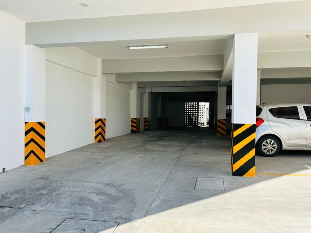 A parking garage with concrete floors and pillars marked with yellow and black chevrons.