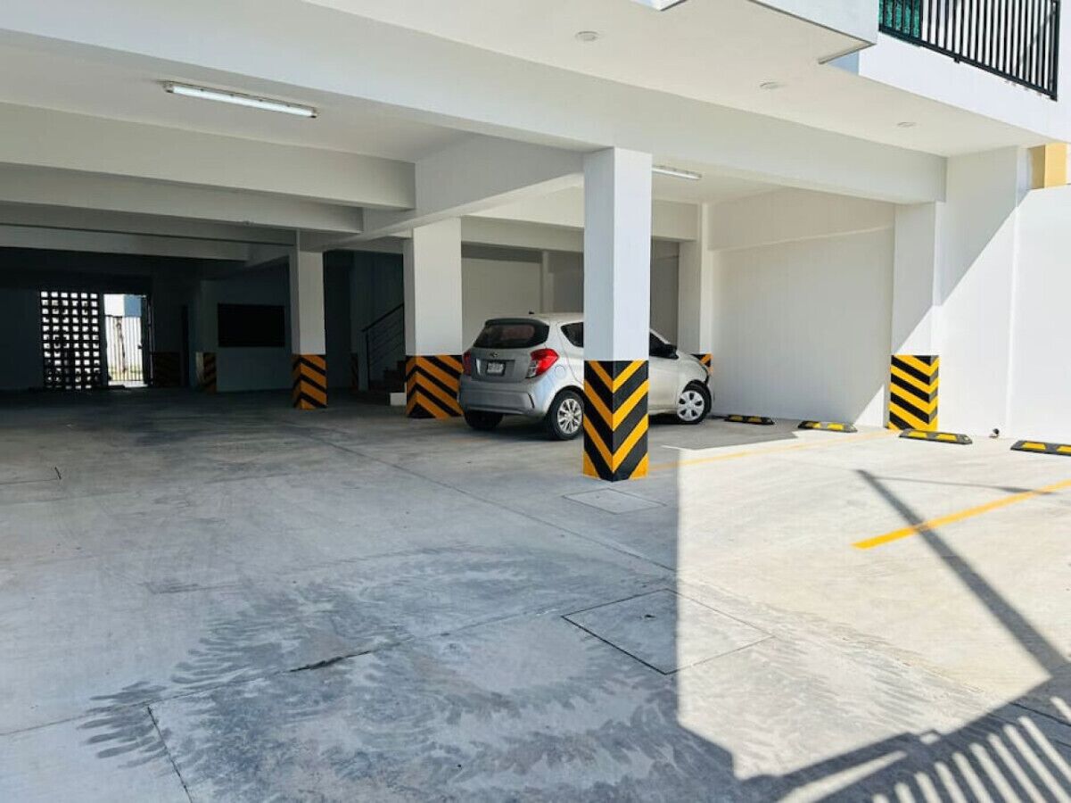 A multi-level parking garage with concrete floors and yellow and black striped bollards.