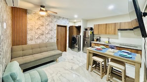 Una cocina moderna con zona de comedor, un sofá y un ventilador de techo.