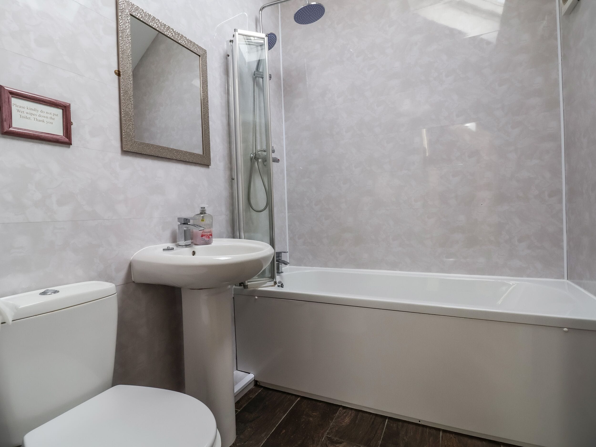 A bathroom with a toilet, sink, and bathtub.