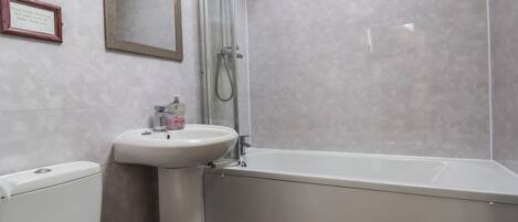 A bathroom with a toilet, sink, and bathtub.