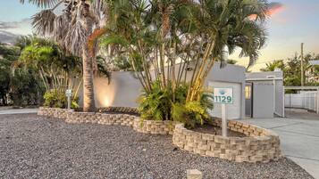 A residential property with a landscaped garden, a palm tree, and a mailbox with the number 1129.