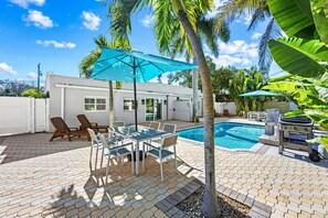 A backyard with a swimming pool, patio furniture, and a barbecue grill. - Key Life Living l Private Heated Pool & 5 Minute Walk to Crescent Beach (Siesta Key)
