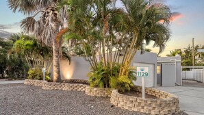 A residential area with a house number 1129, surrounded by palm trees and a gravel driveway. - Key Life Reef l Semi-Private Pool, Walk to the Beach! (Siesta Key)