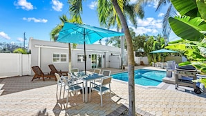 A backyard with a swimming pool, patio furniture, and a barbecue grill. - Key Life Reef l Semi-Private Pool, Walk to the Beach! (Siesta Key)
