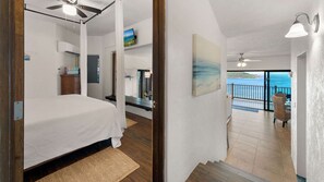 Une chambre avec un lit, un ventilateur de plafond et une vue sur l’océan.