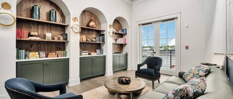 Un espace de détente moderne comprenant un canapé, des fauteuils, une table basse et des étagères.