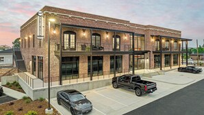 A hotel with a brick facade, large windows, and a covered outdoor seating area. - 5 Minutes from I65 | In the heart of Cullman | Experience The Frankweiler (Cullman)
