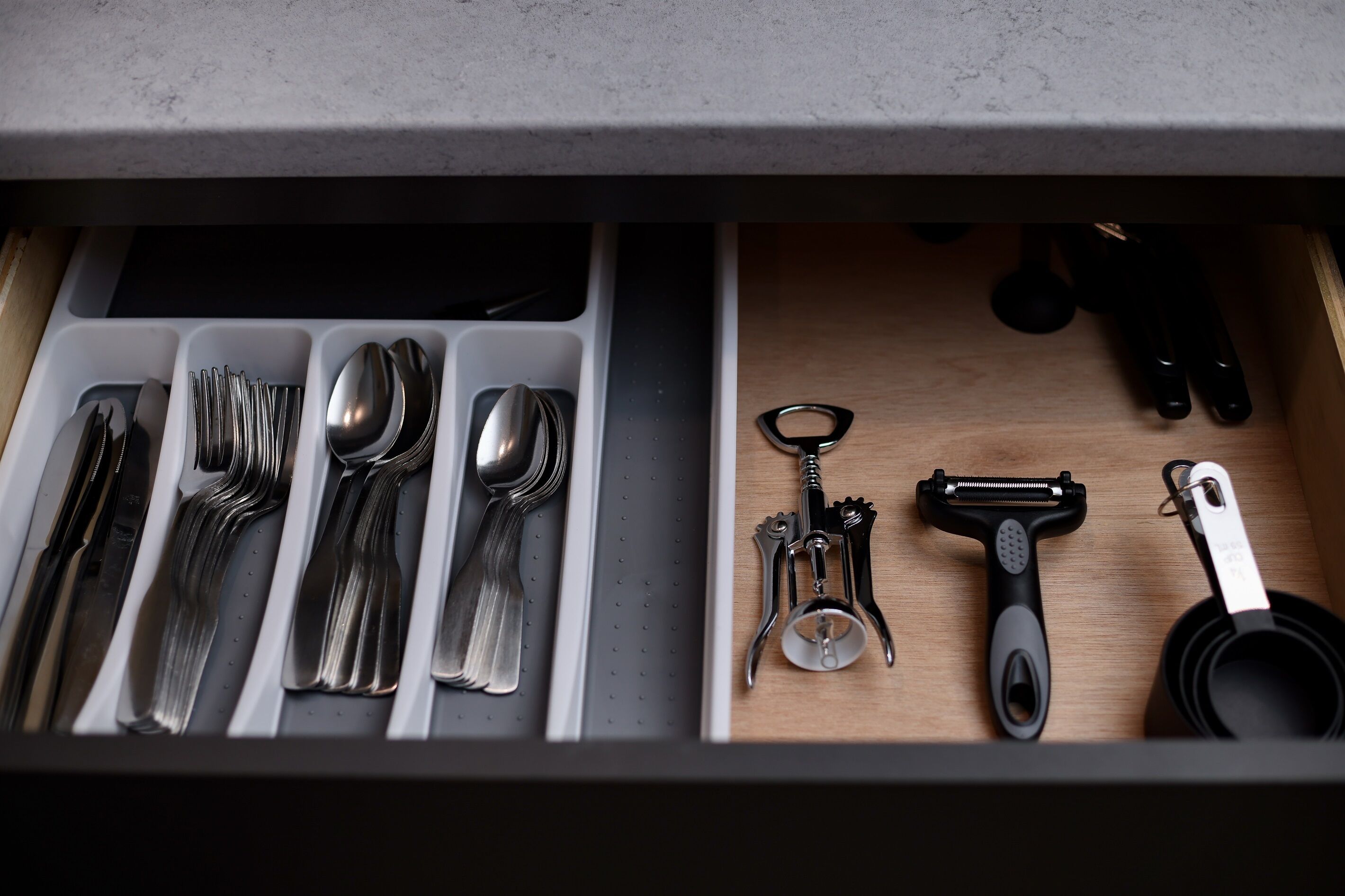 A drawer with utensils and kitchen tools.