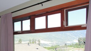 Una habitación con un amplio ventanal que da a un paisaje montañoso.