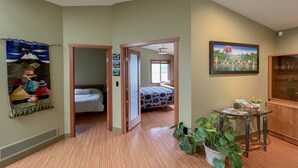 Una habitación de hotel con una cama, una mesita con plantas y un cuadro en la pared.